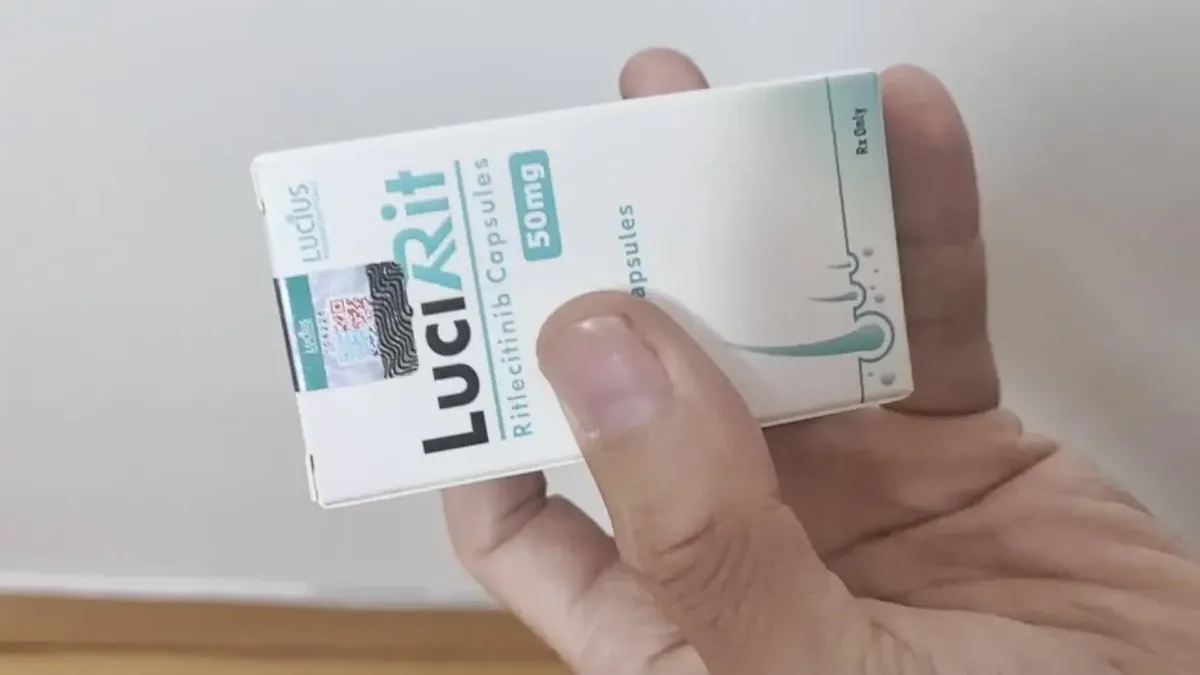 患者手持处方单和利特昔替尼药盒,在医院药房窗口咨询用药信息